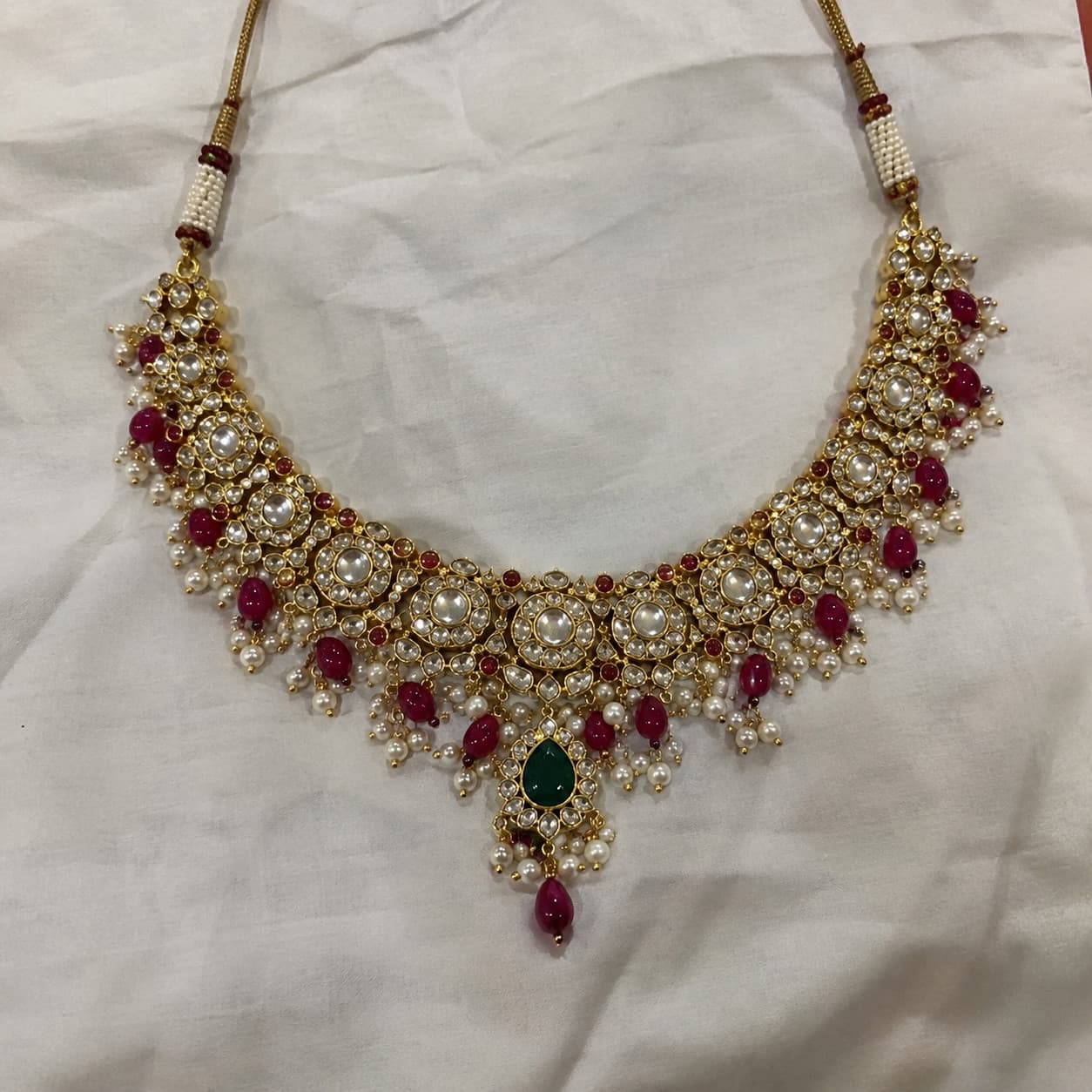 Phone photo of the same necklace on a plain cloth